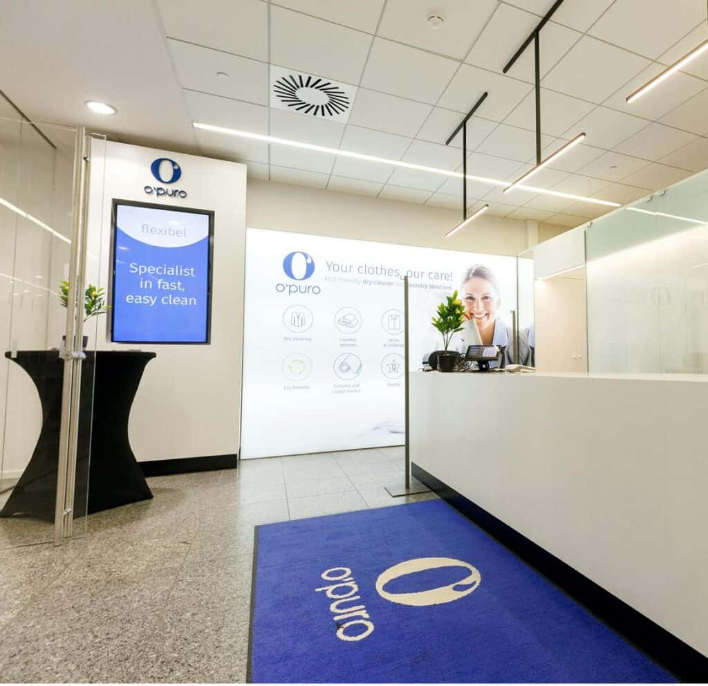 2. Alternatieve tekst: Modern receptiegebied van Opuro met bedrijfsbranding en informatieschermen.